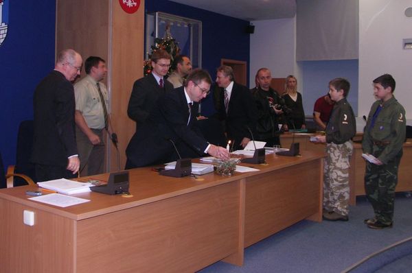 Przewodniczący Piotr Kurpios stawia światełko na stole prezydialnym.